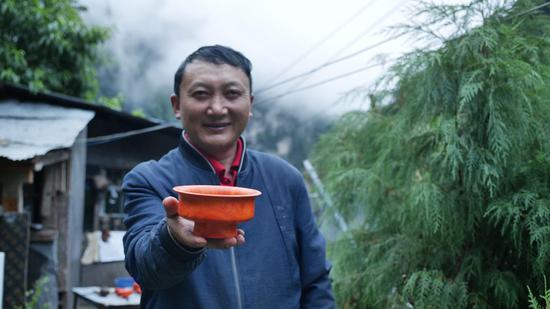  扎西巴珠展示他制作的木碗。新華網(wǎng) 旦增努布攝